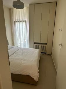 a bedroom with a white bed and a window at Villa Elodie, Green Coast, Palase in Palasë