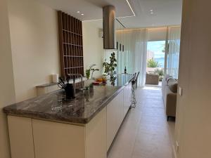 a kitchen with a counter top and a living room at Villa Elodie, Green Coast, Palase in Palasë