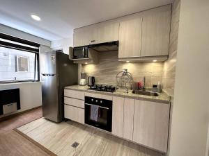 a kitchen with a sink and a stove top oven at Cozy smart studio & home office in La Paz