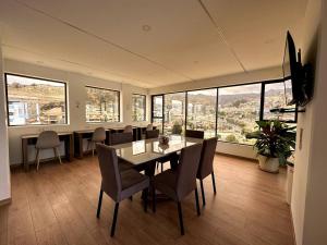 a dining room with a table and chairs and windows at Cozy smart studio & home office in La Paz
