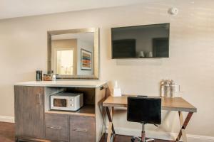 a room with a desk with a microwave and a mirror at Hotel 414 Anaheim in Anaheim