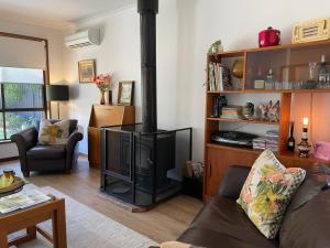 a living room with a wood burning stove at Poppies Clunes in Clunes