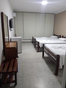 a hospital room with three beds and a tv at Hotel Libertador in Santa Cruz de la Sierra