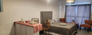 a bedroom with a bed with a table and chairs at Conesa Suite in General Sarmiento