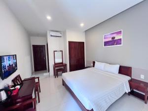 een slaapkamer met een bed, een bureau en een stoel bij Lavender Resorts Phu Quoc in Phu Quoc