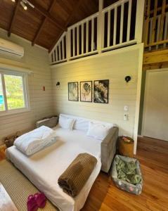 a bedroom with a large white bed in a room at Chalé Top Condado Urubici, banheira e piscina aquecida in Urubici