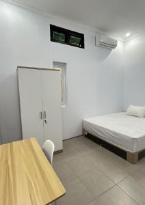 a white room with a bed and a table at Aero Guest House in Timuran