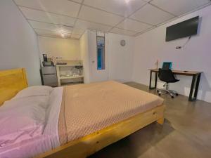 a bedroom with a bed and a desk and a computer at Yurrita Citadin in Guatemala
