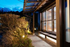 a bench on a porch of a house at night at 箱根寄月庵 in Hakone