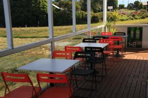 a row of tables with chairs and umbrellas at Otway Junction Motor Inn in Lavers Hill