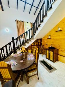 a dining room with a table and chairs and stairs at Green field Inn in Wellawatta +17 photos