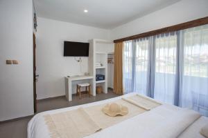 a bedroom with a bed with a hat on it at Baliterraneo Boutique Resort in Seminyak