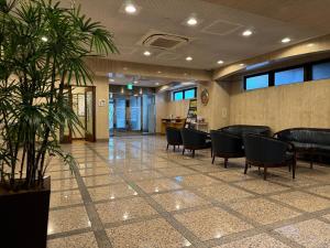 a waiting room with chairs and a plant at Smile Hotel Sugamo in Tokyo
