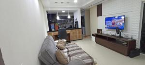a living room with a couch and a flat screen tv at Casa por temporada em Garanhuns in Garanhuns