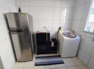 a kitchen with a refrigerator and a washing machine at Apartamento Tranquilidade! in Uberaba