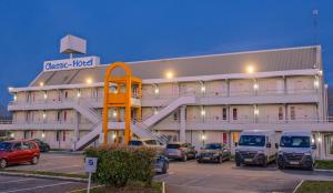 Un gran edificio con coches aparcados en un estacionamiento. en Classic Hôtel - Fontenay-Trésigny, en Fontenay-Trésigny 12 fotos más
