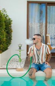 a man sitting in a pool with a hose at Baliterraneo Boutique Resort in Seminyak