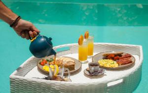 a table with two plates of food and drinks at Baliterraneo Boutique Resort in Seminyak