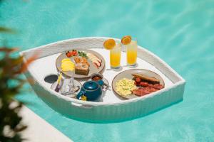 a tray of food in a small boat in a pool at Baliterraneo Boutique Resort in Seminyak