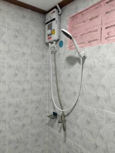 a shower in a bathroom with a hose on a wall at Suansubtawee Resort in Ban Baketa