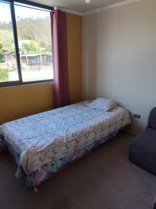 Un pat sau paturi într-o cameră la Departamento en Dichato