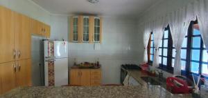 eine Küche mit Holzschränken und einem Kühlschrank in der Unterkunft Microcasa Mar Verde in Caraguatatuba + 17 Fotos