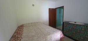 ein Schlafzimmer mit einem Bett, einer Kommode und einem Spiegel in der Unterkunft Microcasa Mar Verde in Caraguatatuba