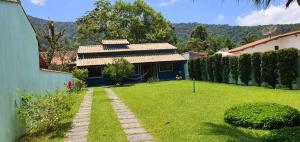ein Haus mit einem Rasenhof mit einem Haus in der Unterkunft Microcasa Mar Verde in Caraguatatuba