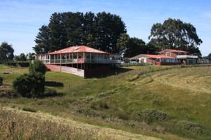 a house on a hill in a field at Otway Junction Motor Inn in Lavers Hill