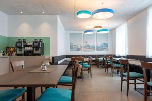 a dining room with wooden tables and blue chairs at Best Western Hotel Kiefersfelden in Kiefersfelden