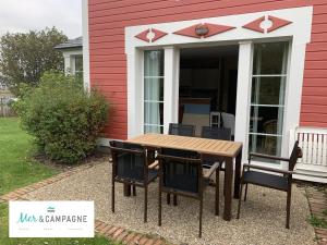 a table and chairs in front of a house at Maison familiale 3 chambres proche plage et golf à Fort-Mahon-Plage - FR-1-482-95 in Fort-Mahon-Plage +6 photos