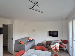 a living room with a couch and a tv at Maison familiale 3 chambres proche plage et golf à Fort-Mahon-Plage - FR-1-482-95 in Fort-Mahon-Plage