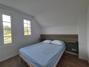 a bedroom with a bed with two pillows and two windows at Maison familiale 3 chambres proche plage et golf à Fort-Mahon-Plage - FR-1-482-95 in Fort-Mahon-Plage