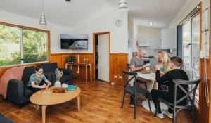 un grupo de personas sentadas en mesas en una sala de estar en Holiday Haven Burrill Lake, en Burrill Lake