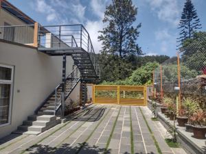a staircase leading up to a house with a fence at Iniyan Nestle in Yercaud