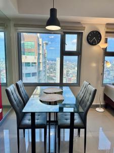 une salle à manger avec une table, des chaises et une horloge dans l'établissement Cozy 1BR Condo in Manila Near US Embassy and Robinsons Place Manila, à Manille 3 autres photos