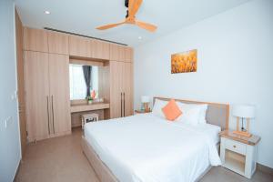 a bedroom with a white bed and a ceiling fan at Sanctuary Villa Ho Tram in Ho Tram +25 photos