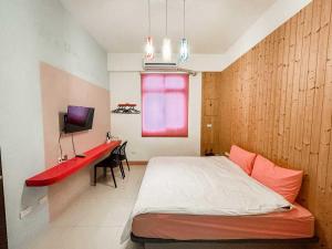 a bedroom with a bed and a desk and a television at 澎湖樂在綺中民宿 第580號 in Magong