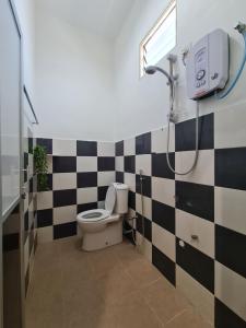 a bathroom with a black and white checkered wall at Casa Yusika in Pantai Cenang +47 photos