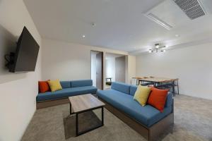 a living room with a blue couch and a table at Minn STATION Ai Nagoya in Aoichō