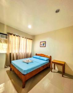 une chambre avec un lit avec des draps bleus et une fenêtre dans l'établissement Villa Paraiso Resort & Waterpark, à Mambajao