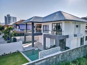 a large white house with a swimming pool at Luxury Executive 5 Bedroom Pool Villa in Jomtien - J5 in Jomtien Beach