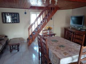 un soggiorno con scala, tavolo e TV di Maison 5 personnes à Barbâtre, proche plage, animaux admis - FR-1-823-3 a Barbâtre