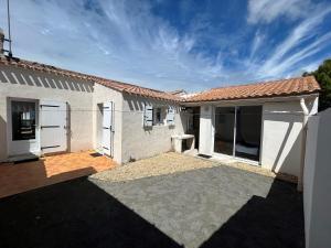 a small white house with a patio at Maison à La Guérinière, proche plage, pour 6 personnes avec wifi - FR-1-823-25 in La Guérinière