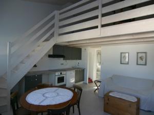 a living room with a table and a staircase at Appartement à Noirmoutier 4 personnes avec parking - FR-1-823-31 in Noirmoutier-en-l'lle