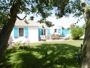 una casa blu e bianca con tavolo e sedie di Maison confortable 4 pers. avec jardin fermé à L'Épine, proche plage - FR-1-823-27 a LʼÉpine