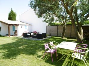 un cortile con due sedie, un tavolo e un tavolo di Maison confortable 4 pers. avec jardin fermé à L'Épine, proche plage - FR-1-823-27 a LʼÉpine Altre 3 foto
