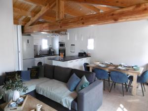 un soggiorno con un divano, un tavolo e una cucina di Maison confortable 4 pers. avec jardin fermé à L'Épine, proche plage - FR-1-823-27 a LʼÉpine