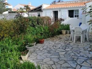 a patio with a table and chairs in a yard at Maison à Noirmoutier proche plage, animaux admis - FR-1-823-34 in Noirmoutier-en-l'lle