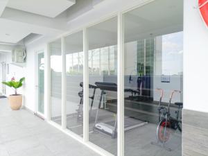 Una sala de estar abierta con paredes de vidrio y un gimnasio. en Elegant and MInimalist Studio at Mataram City Apartment By Travelio, en Kejayan